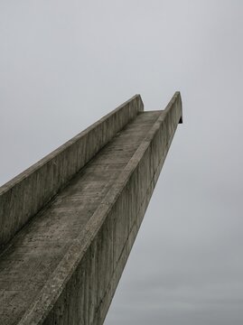 Concrete Ramp Vanishing into Gray Sky. Minimal brutalist form