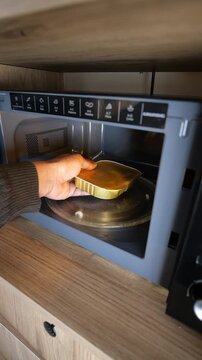 Microwave cooking in small kitchen at home