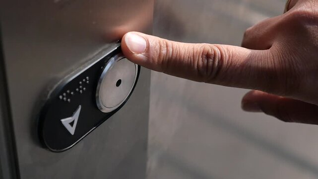 Press button to go down in elevator at office building