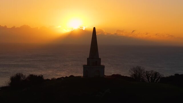 4K Cinematic drone footage, Silhouette of an obelisk at Killiney Hill during a stunning sunrise over the Dublin coastline. Perfect for travel and nature projects.09