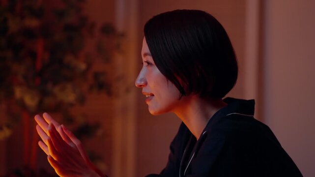 パジャマ姿で手を温める女性