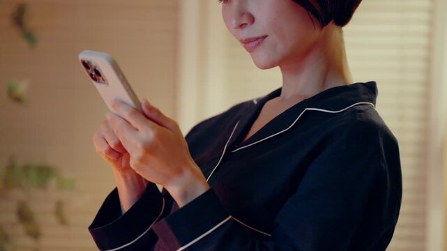 パジャマでスマホを見る女性