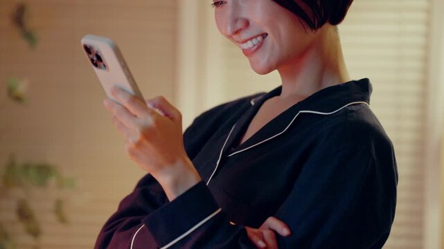 パジャマでスマホを見る女性