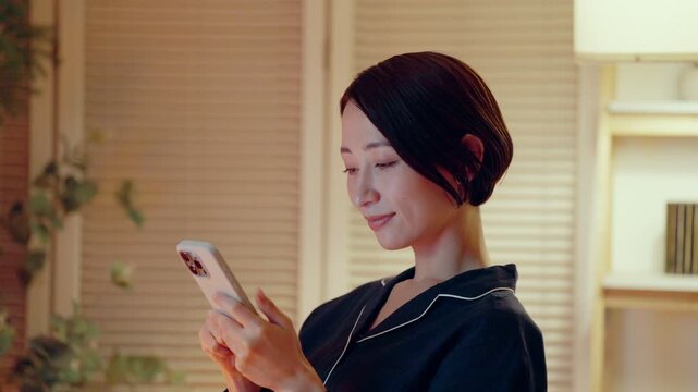 パジャマでスマホを見る女性