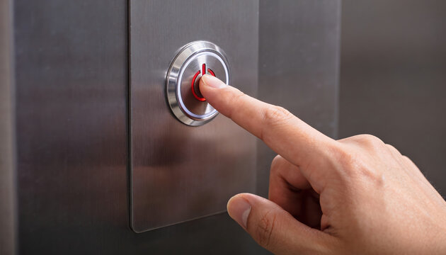 Human hand actively presses red illuminated button sleek metal elevator panel. Finger engages control, signaling readiness for transport