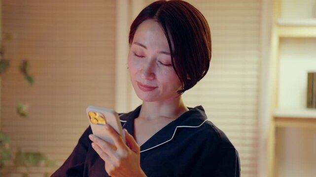 パジャマでスマホを見る女性