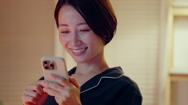 パジャマでスマホを見る女性