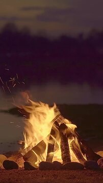 camp fire burning in the beach at night
