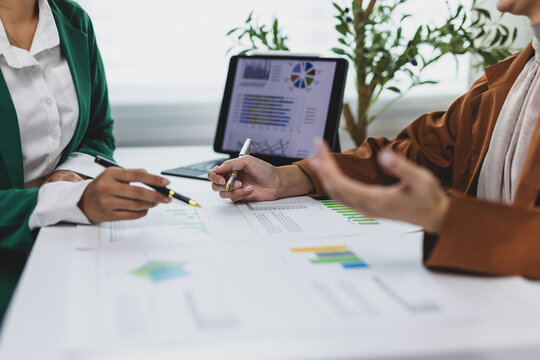 Businesswoman engaging in a discussion about marketing strategy, analyzing charts and graphs that illustrate company performance during a meeting in office.