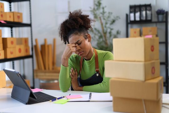 Stressed young entrepreneur woman holding head with hands suffering from headache.