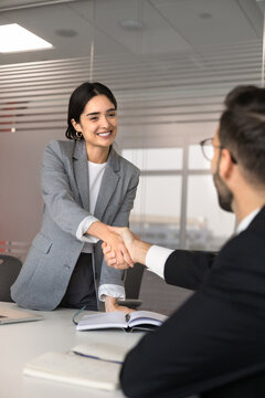 Portrait of smiling businesswoman, female applicant greeting, handshake with male HR manager starting job interview, completing meeting successfully. Human resources, employment, business partnership