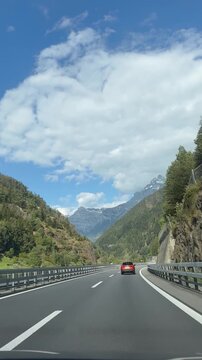 Experience the stunning aerial view of a Swiss mountain road winding through lush forests and dramatic cliffs. Perfect for vertical video on social media, highlighting pristine alpine landscapes.