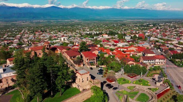 Aerial footage of Telavi, Georgia, showcasing the urban area, scenic surroundings, and majestic Caucasus mountain range in the distance.