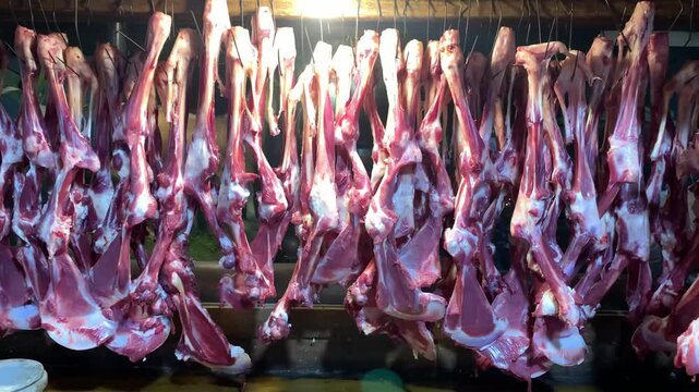 Fresh lamb carcasses hanging in a row in a butchery