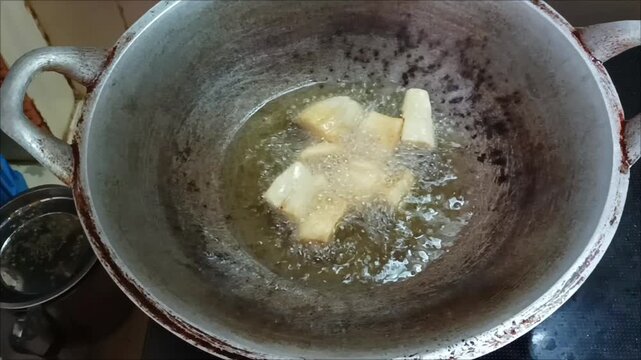 Fry fresh cassava pieces in a pan