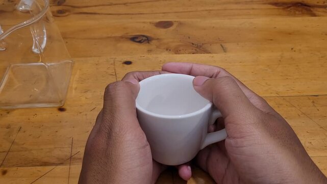 Hand hold cup and rubbing it
Show hesistate or anxious