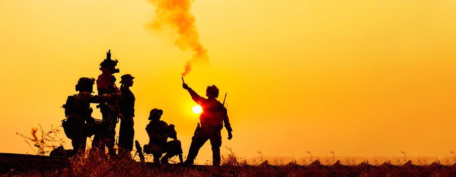 Silhouetted Soldiers Deploy Flares During Sunset Training Exercise, Two Soldiers in Camouflage Gear Holding Flares and Rifles Amidst an Orange Sky, Ready for Action