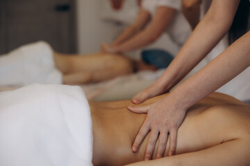 Fototapeta premium People receiving back massage during wellness therapy session
