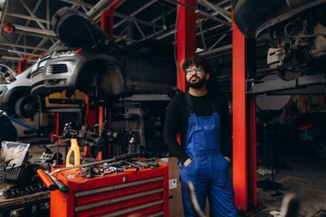 Fototapeta premium Auto mechanic standing in car repair workshop