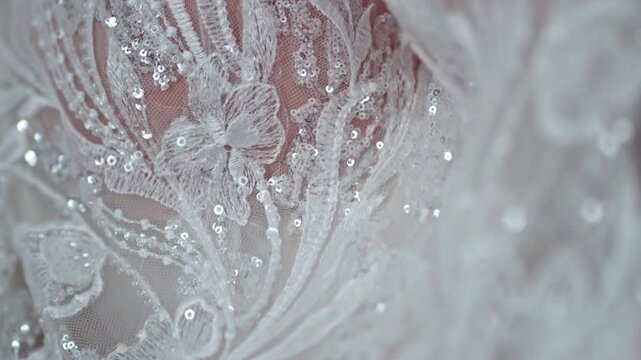 Delicate white lace detail with sequins, evokes elegance and craftsmanship