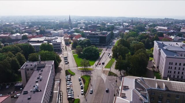 Aerial establishing shot toward sun over Liepaja center park streets and mall