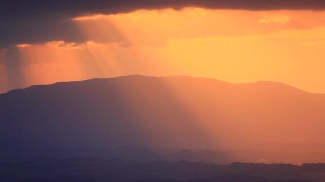 大黒森から望む早池峰山と折爪岳などの山並みと朝の光芒