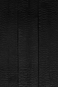 Charred wood texture background with burned surface and deep gra