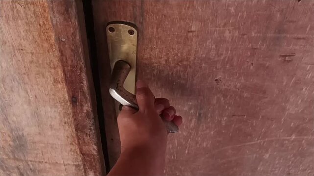 Hand Opening Vintage Metal Lever Door Handle on Old Wooden Door