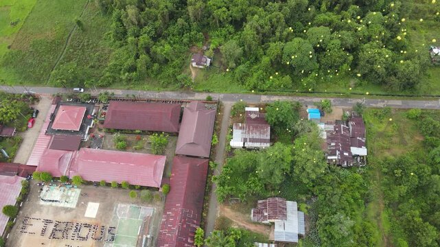 Drone aerial rural village with balloon cluster over green forest