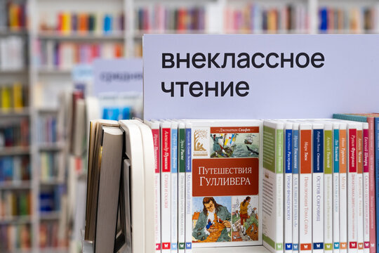 Moscow, Russia - April 14, 2026: Books displayed on shelf in library with sign for extracurricular reading in Russian language, Gulliver's Travels featured