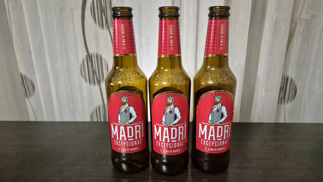 Three amber glass bottles of Madri Excepcional beer stand in a row against a neutral background. Picture taken on April 13, 2026 in Bucharest, Romania.