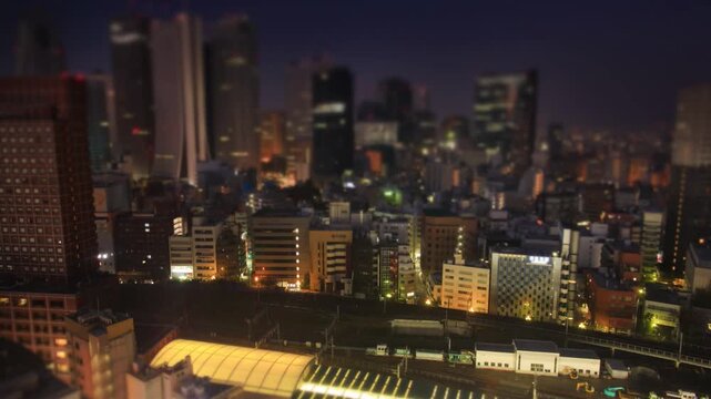 新宿のビル群と行き交う電車の夜景と朝から昼のミニチュア風景