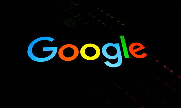 Vibrant Multicolored Google Logo Glowing Against a Dark Backlit Mechanical Gaming Keyboard Background - Concept for Modern Search Engine Tech, Digital Marketing, and Online Innovation