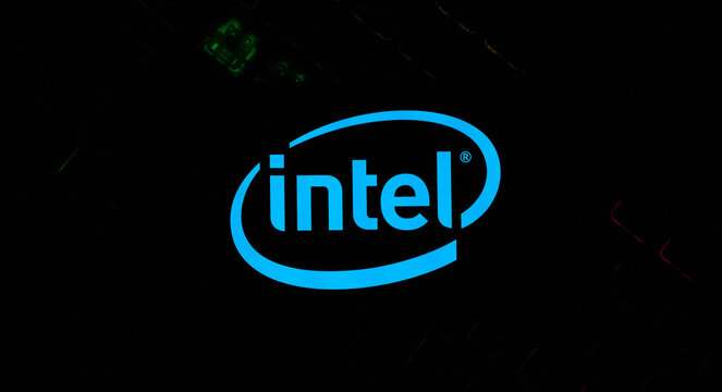 Blue Intel Logo Glowing Vibrantly Against a Dark Backlit RGB Mechanical Gaming Keyboard Background - Concept for Modern PC Hardware, Semiconductor Innovation, and Global Tech Branding Trends