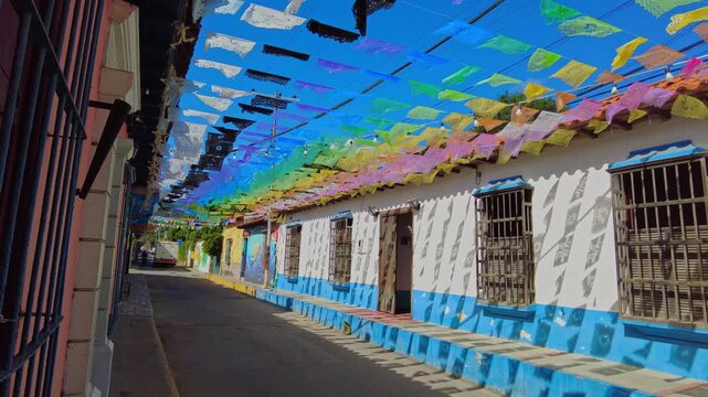 A view of colonial architecture with colorful pennants hanging on a sunny day in Choroni, Aragua, Venezuela.