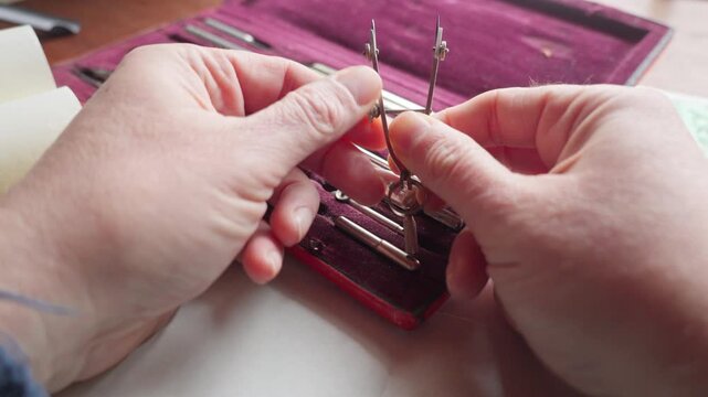 POV shot of hands adjusting a compass screw, highlighting calibration, control, and the importance of precision in technical design.