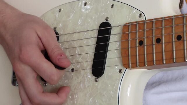 Using a pick to alternate pick and then strum the strings of the guitar