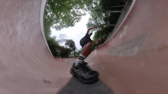 Point of view shot of a skateboarder riding in a concrete skatepark ramp