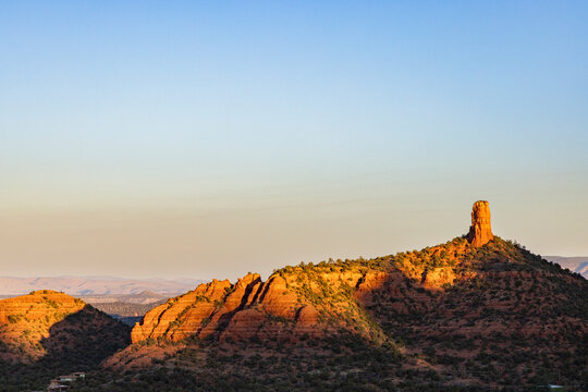 Monolithic rock formation rsing up from landscape sunrise