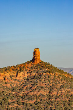 Lone vertical monolithic rock formation rising from landscape