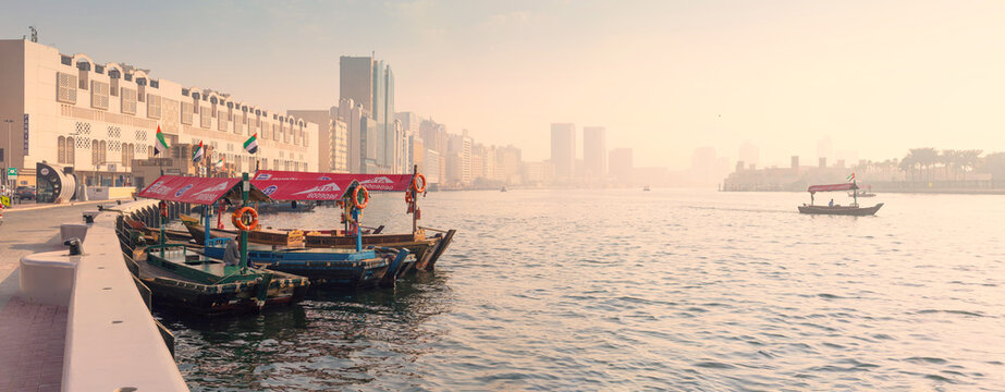 12 January 2026, Dubai, UAE: Traditional abra boats waiting for passengers on Creek, with the historic Bur Dubai skyline and mosque minaret in the background