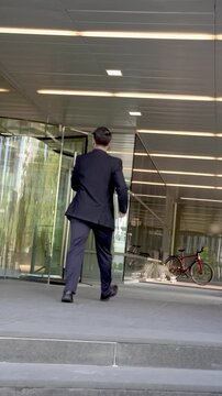 Businessman carrying a laptop entering office building