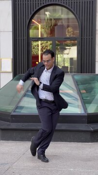 Successful businessman celebrating with a happy dance in the street
