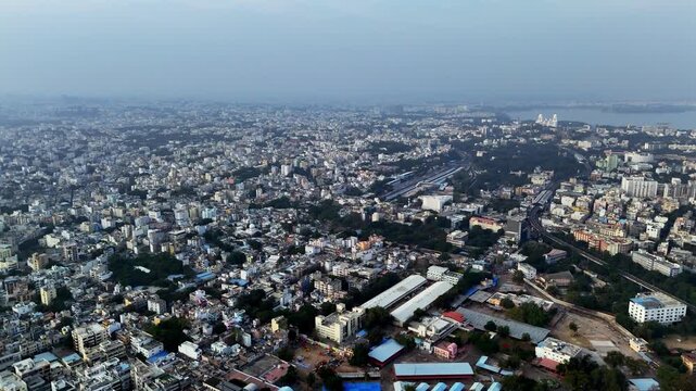 Wide cinematic aerial of Nampally Railway Station featuring railway infrastructure, parallel tracks, station sheds, and dense cityscape blending into Hyderabad&rsquo;s vast skyline during winter december