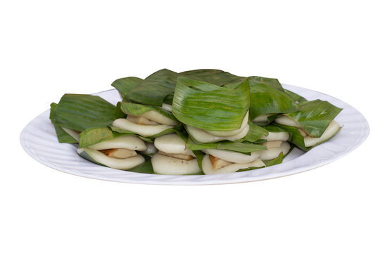 Vietnamese traditional round sticky rice cake (Banh Nep) with meat filling wrapped in banana leaves on a white plate isolated on black transparent background.