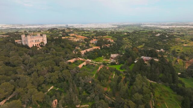 Verdala Palace Within Lush Greenery Of Buskett Woodlands In Siġġiewi, Malta. aerial pullback, ascending shot