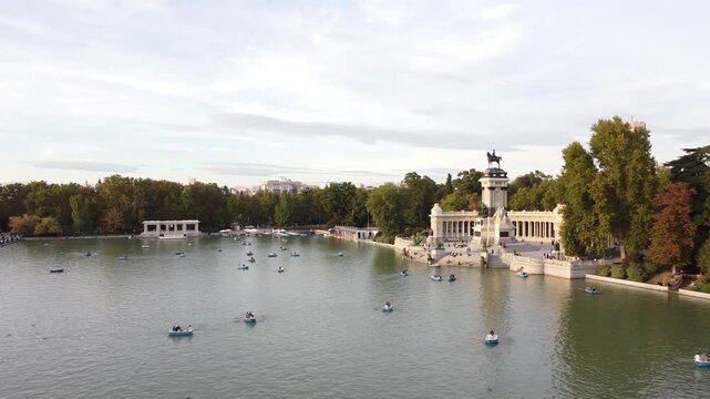 Aerial view of tourists on boats enjoying an autumn day on a great pond in front of monument to Alfonso XII at the Retiro Park (Parque del Buen Retiro) in Madrid, Spain.