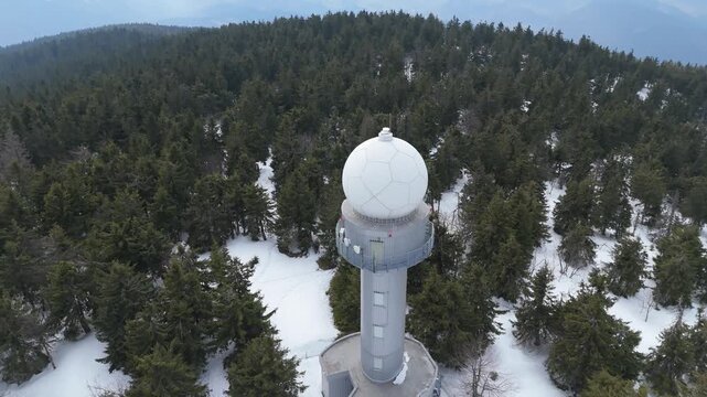 Aerial Pull Away from Meteorological Radar Tower to Snowy Mountain Panorama