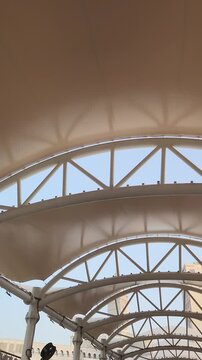 A stunning view of the Makkah Royal Clock Tower rising majestically between modern high-rise buildings in Mecca, Saudi Arabia. The iconic clock face stands tall against the sky, symbolizing Islamic he