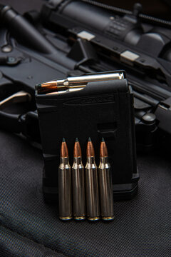 Rifle magazine with 5.56 ammunition and cartridges lined up on a tactical back